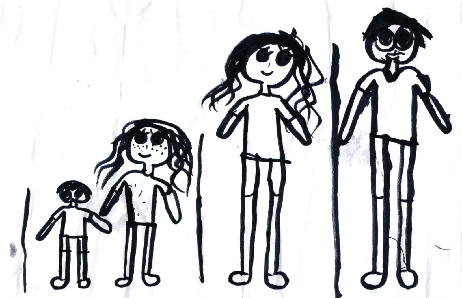A bold black-marker drawing on white paper of a family of four standing side by side against two tall vertical black bars in the background. From left to right: a small child in a t-shirt and pants with a rounded head, short dark hair and large round eyes; an older girl with long flowing dark hair, big round eyes, a spray of freckles across her nose and cheeks, and a small smile, standing beside the smaller child and holding hands; a tall figure with long dark hair pulled to one side, round eyes and a small smile, wearing a t-shirt and long pants; and on the far right the tallest figure — a man with short dark hair, round glasses, a small mustache, wearing a v-neck t-shirt and long pants.